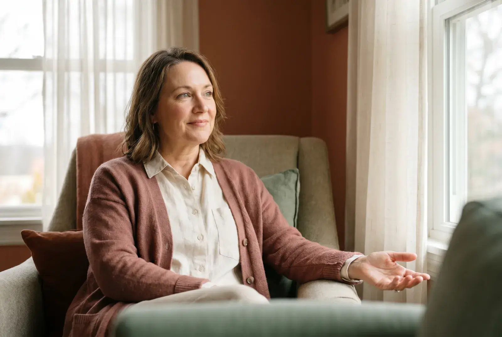 A woman sitting with a calm, grounded, self-assured expression